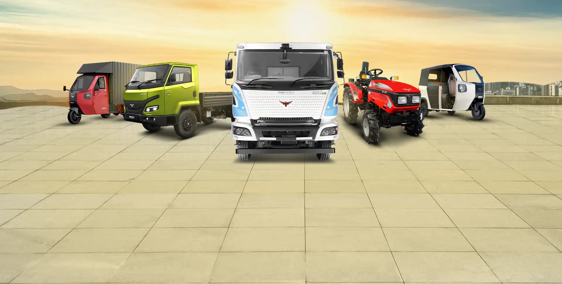 Product range of Montra Electric displayed in a lineup against a plain sky background, showcasing various electric vehicles.